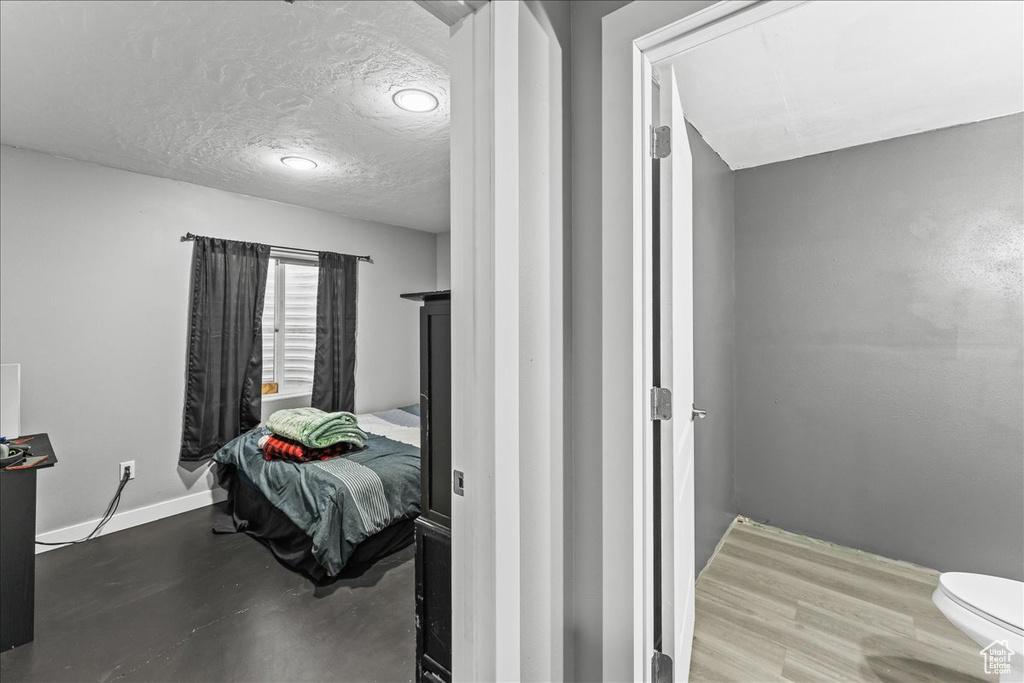 Bedroom with a textured ceiling and wood-type flooring