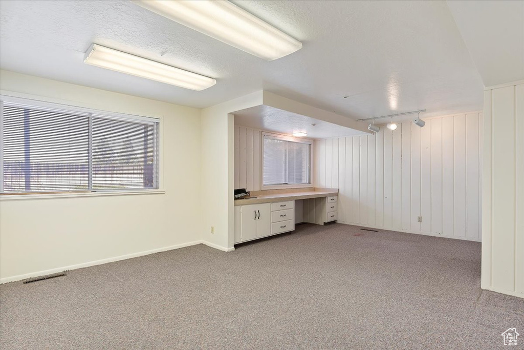Interior space with light colored carpet and built in desk
