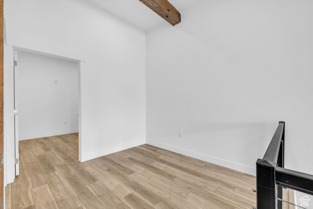Interior space with light hardwood / wood-style floors and beamed ceiling