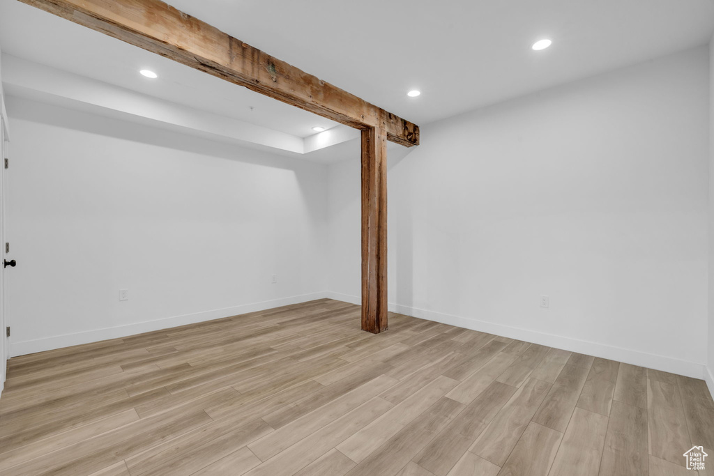 Unfurnished room with beam ceiling and light hardwood / wood-style floors