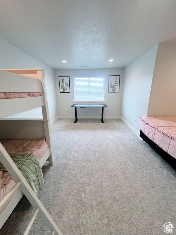 Bedroom with light carpet and a textured ceiling