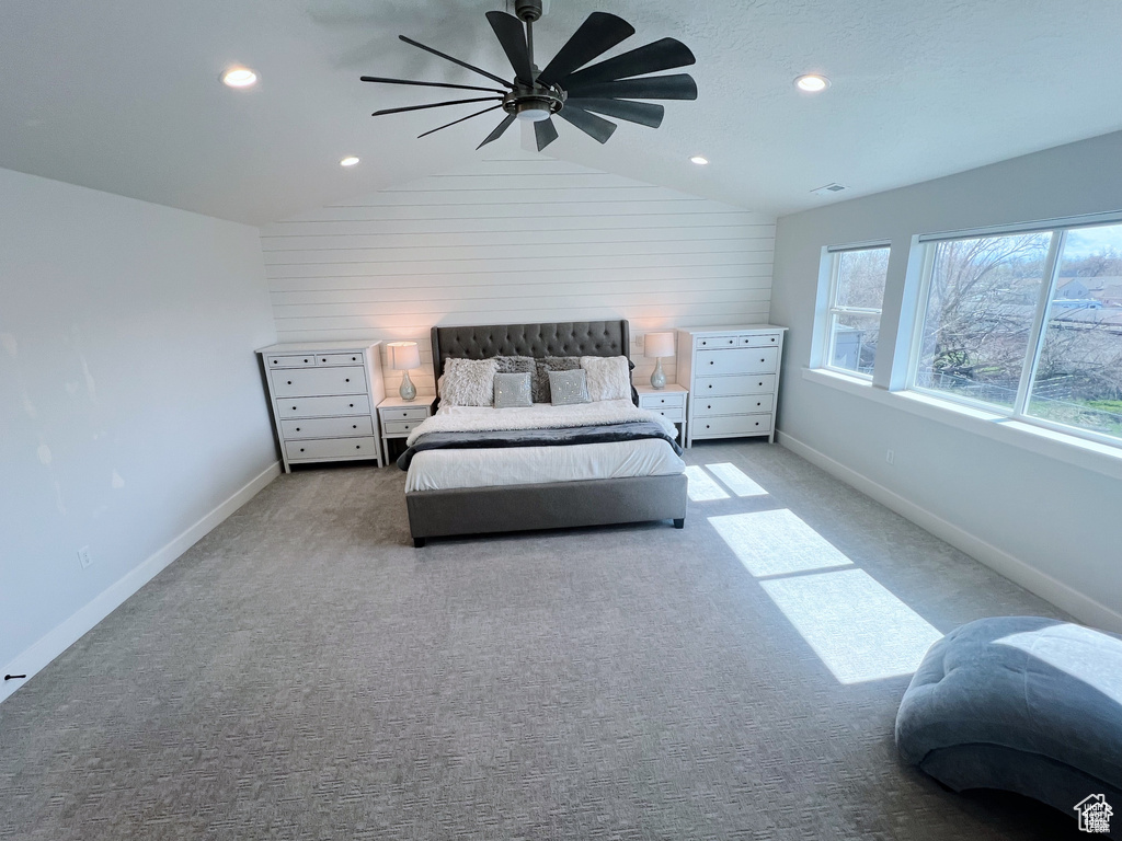 Bedroom with lofted ceiling, ceiling fan, and light colored carpet