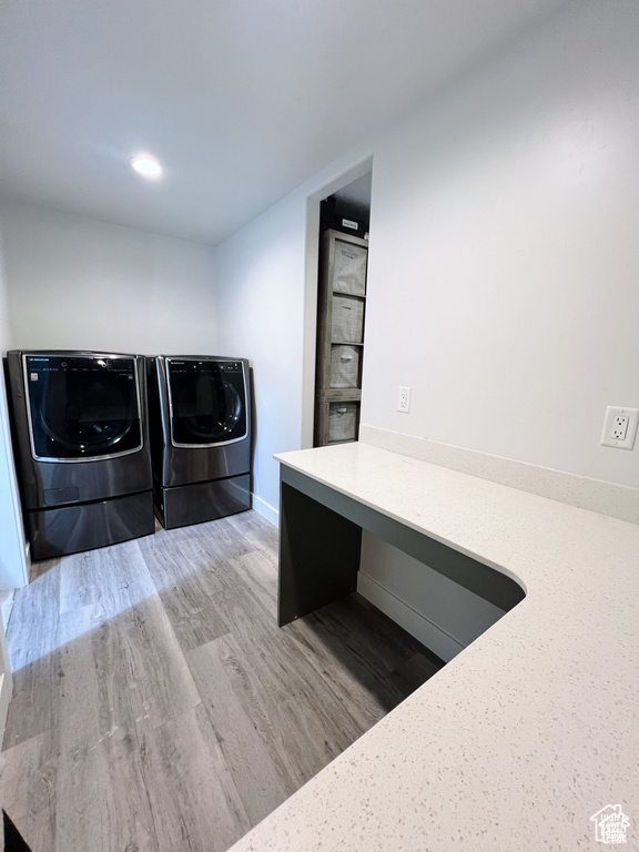 Laundry area with wood-type flooring and washing machine and dryer