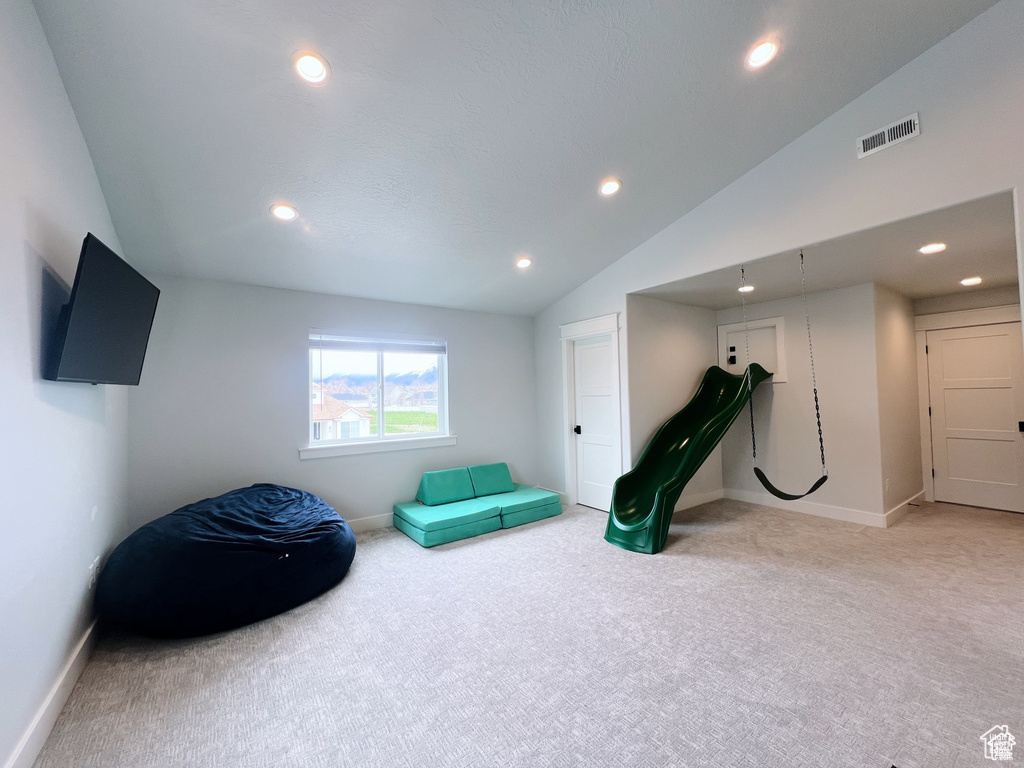 Workout area featuring light carpet and lofted ceiling