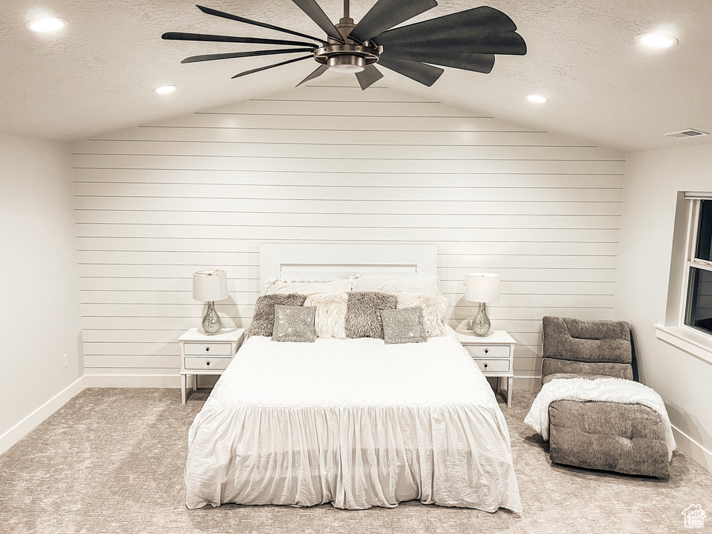 Bedroom with a textured ceiling, light colored carpet, ceiling fan, and lofted ceiling