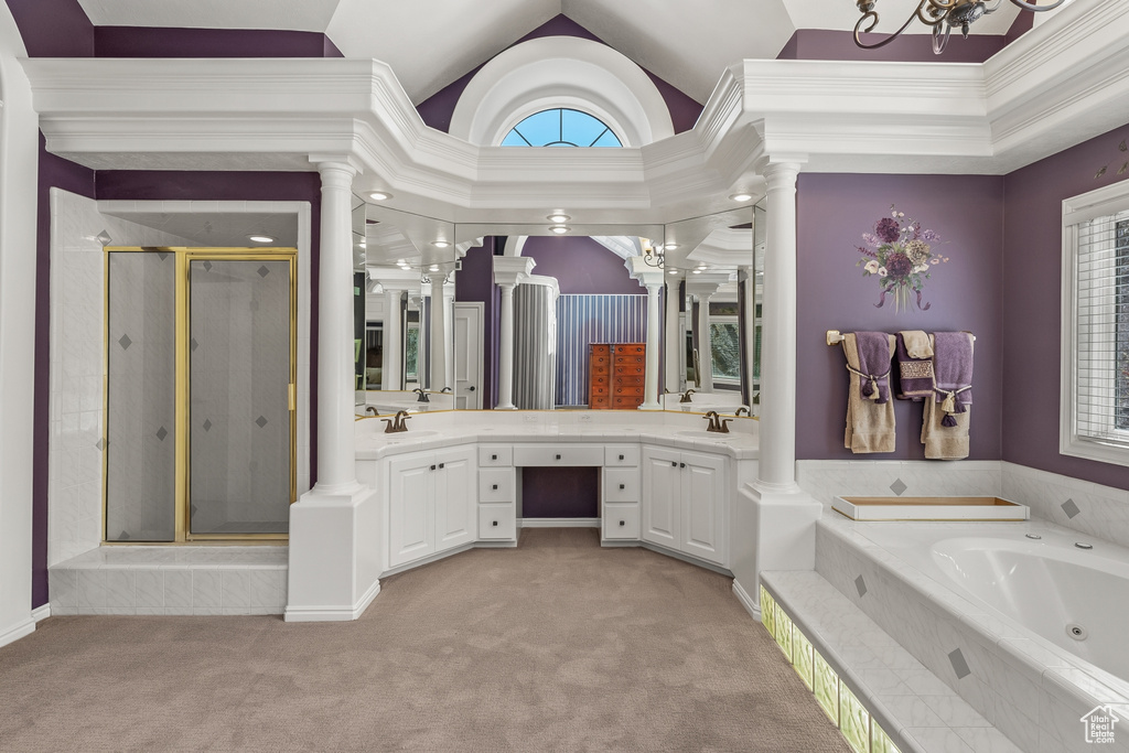 Bathroom with separate shower and tub, dual vanity, a chandelier, and ornate columns