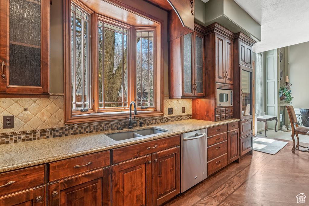Kitchen featuring dark hardwood / wood-style floors, dishwasher, sink, and plenty of natural light