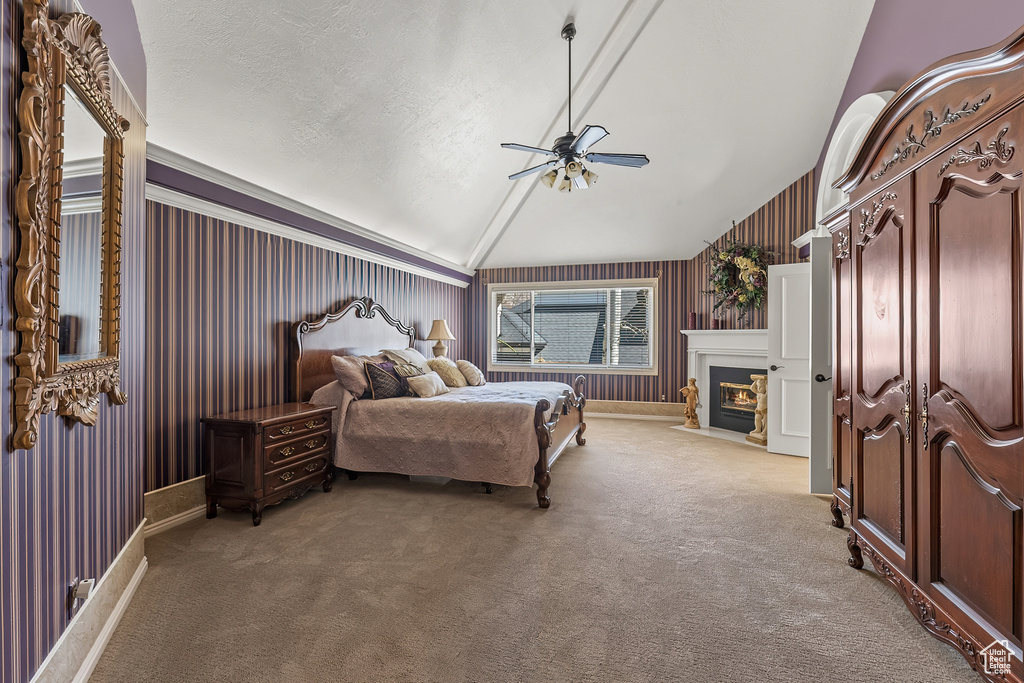 Carpeted bedroom featuring ceiling fan, vaulted ceiling, and a textured ceiling