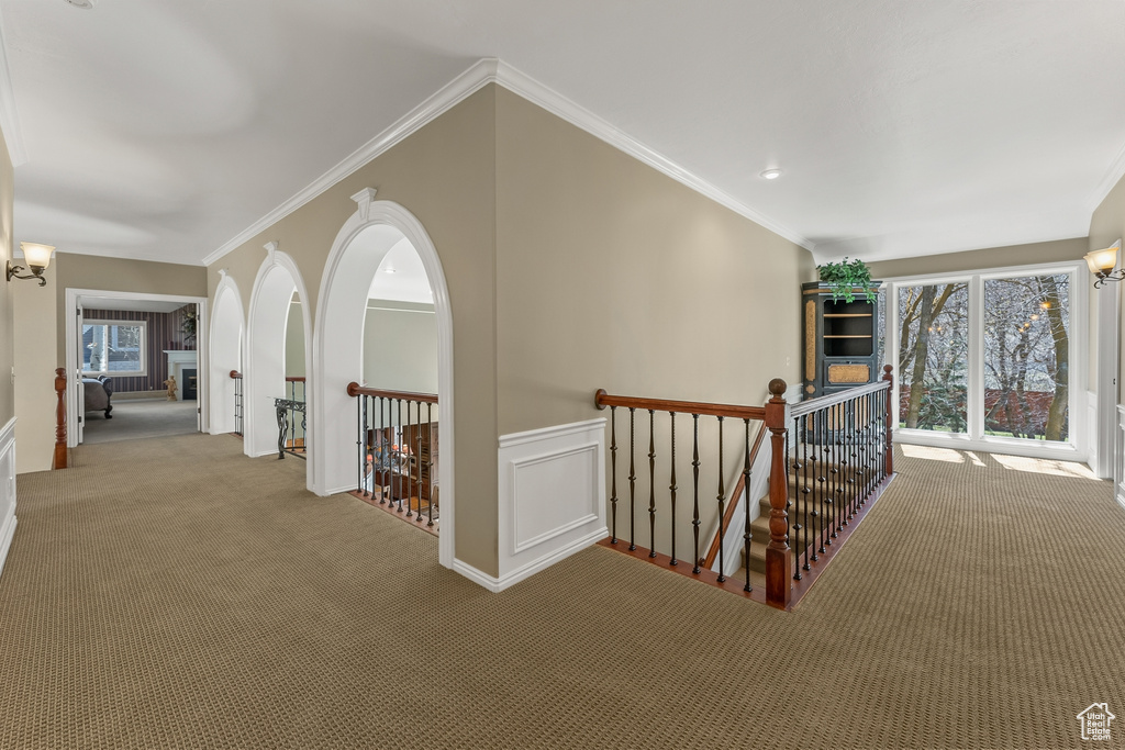 Hall featuring crown molding, a chandelier, and light carpet