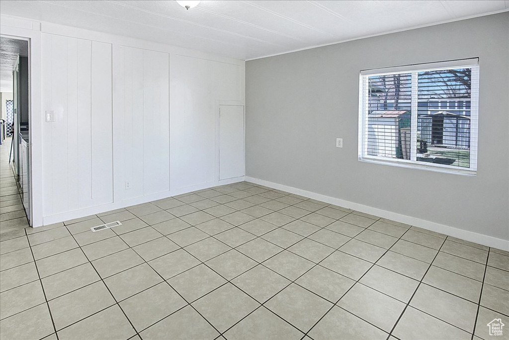 Empty room featuring light tile flooring