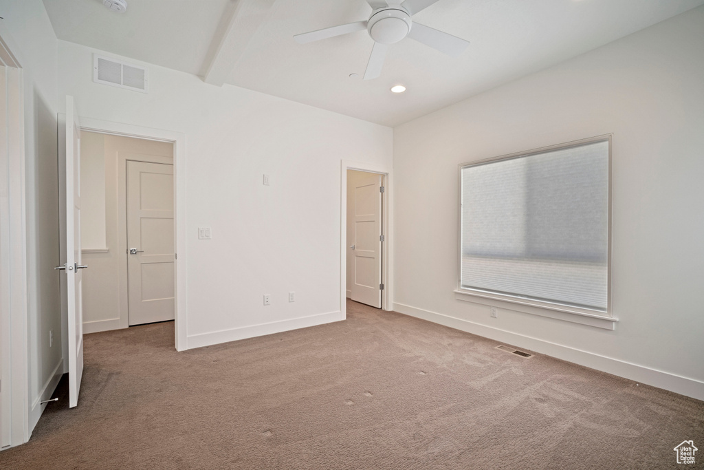 Spare room with light carpet, ceiling fan, and beamed ceiling