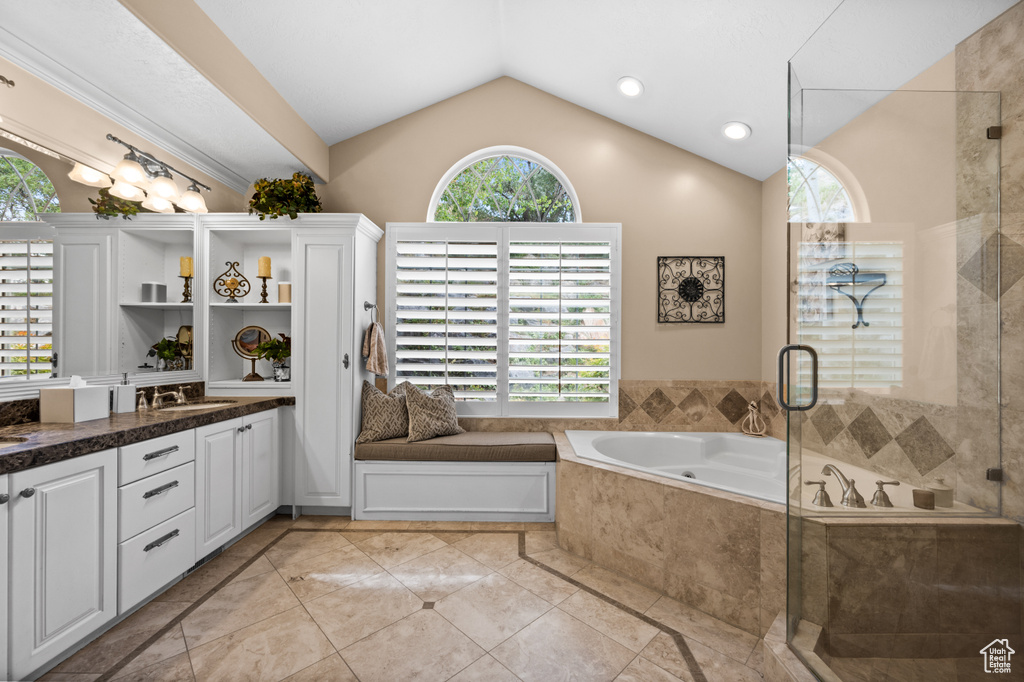 Bathroom featuring shower with separate bathtub, vaulted ceiling, tile floors, and oversized vanity