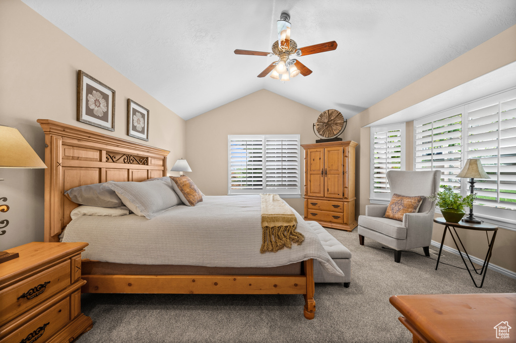 Bedroom with vaulted ceiling, carpet flooring, and ceiling fan