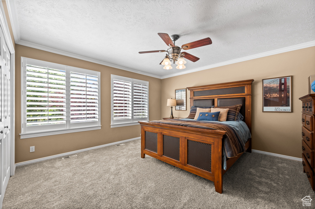Bedroom with light carpet, crown molding, and ceiling fan