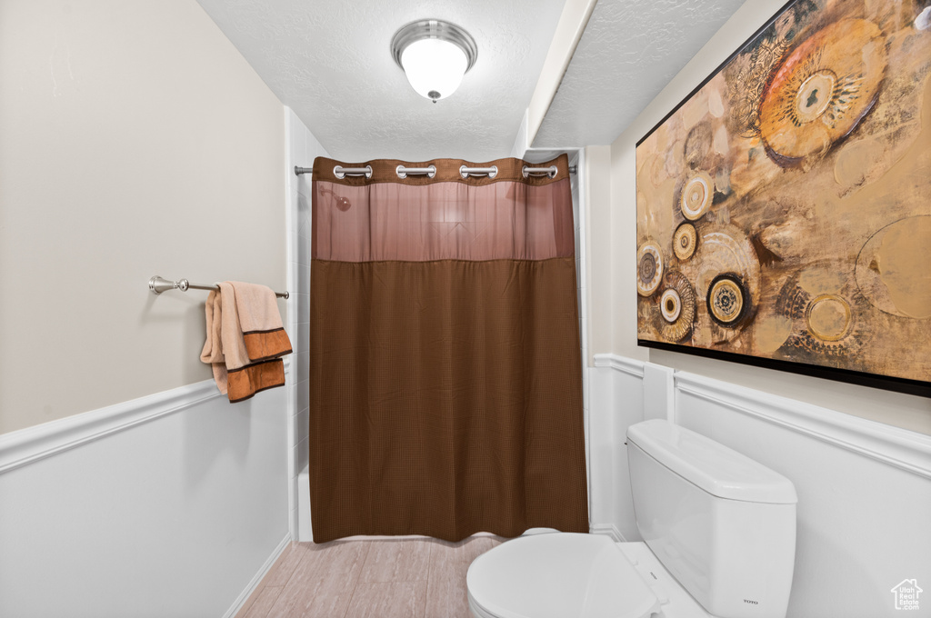Bathroom featuring toilet and a textured ceiling