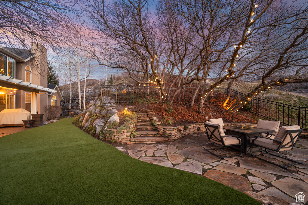 Yard at dusk featuring a pergola and a patio