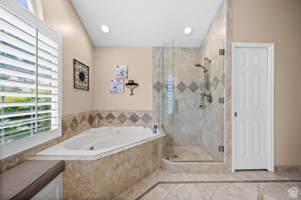 Bathroom with tile flooring, a wealth of natural light, and separate shower and tub