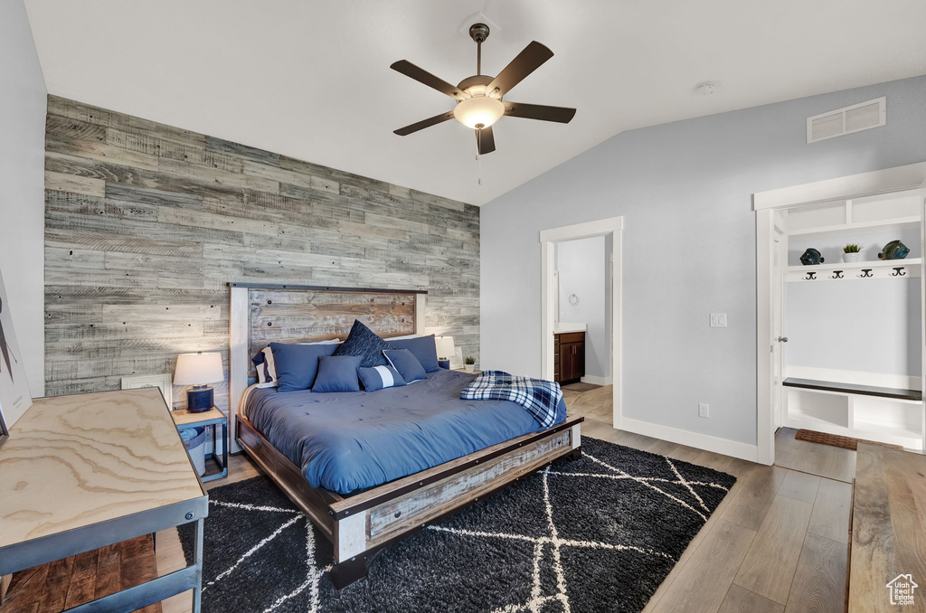 Bedroom with light hardwood / wood-style floors, connected bathroom, and ceiling fan