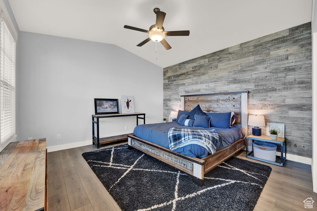 Bedroom featuring ceiling fan, hardwood / wood-style flooring, and vaulted ceiling