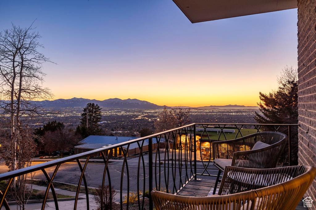 Balcony at dusk featuring a mountain view