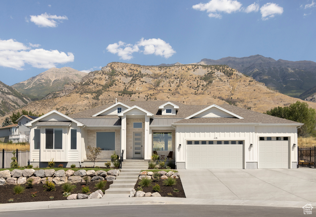 View of front of house with a mountain view and a garage