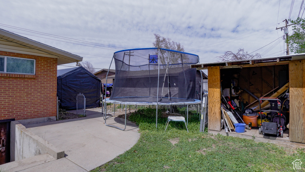 View of yard with a trampoline and a patio
