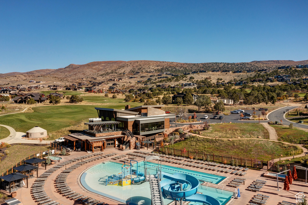 View of swimming pool with a patio area, a mountain view, and a water slide