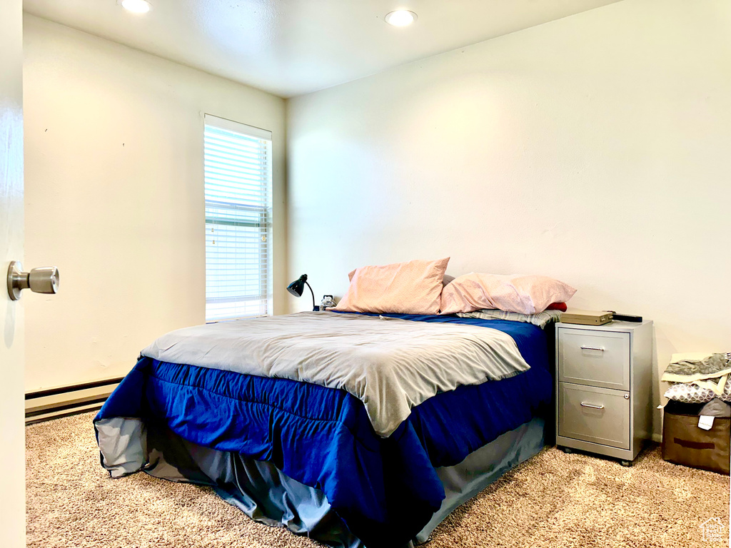 Carpeted bedroom featuring baseboard heating