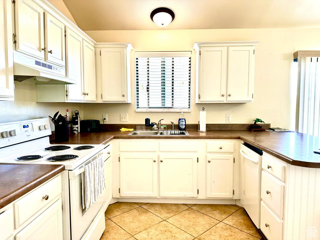 Kitchen featuring white cabinets, light tile floors, white appliances, and sink