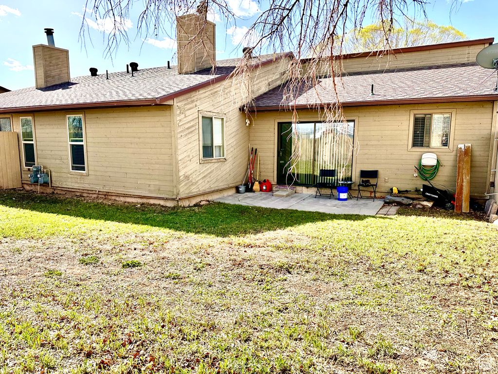 Rear view of property with a yard and a patio
