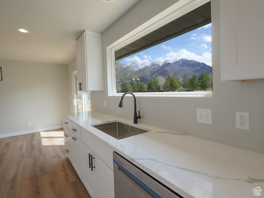 Kitchen with plenty of natural light, a mountain view, white cabinetry, and light stone counters