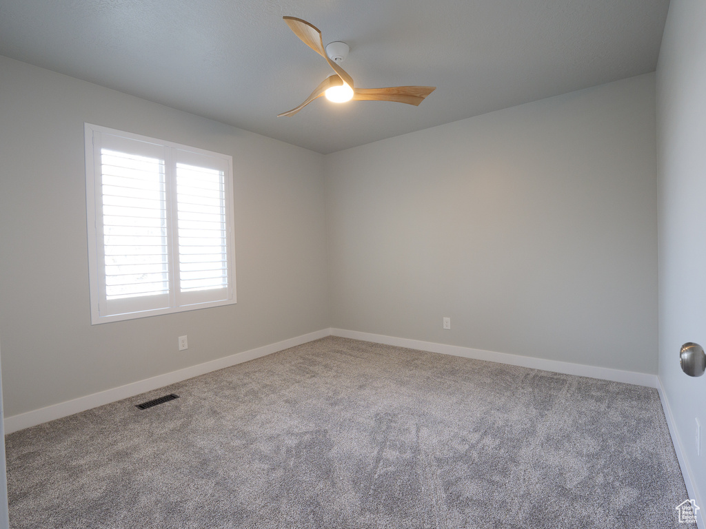 Unfurnished room with ceiling fan and carpet