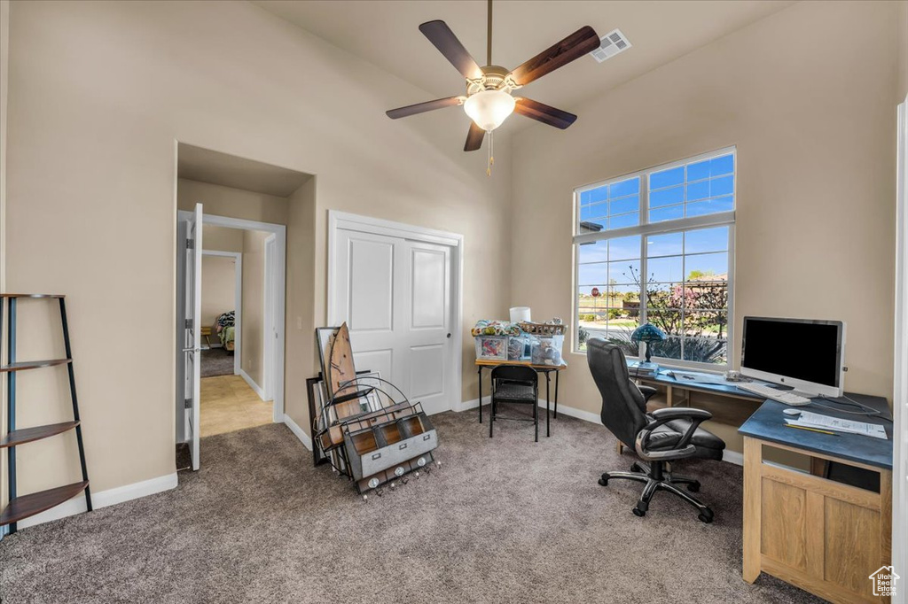 Office area with light carpet, ceiling fan, and high vaulted ceiling