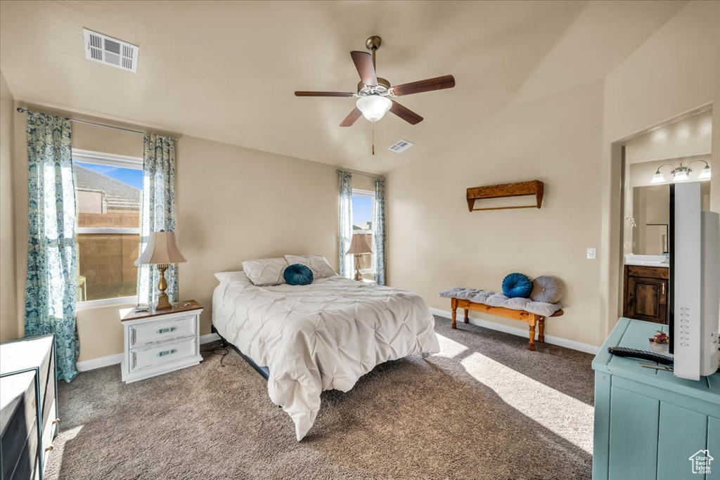 Bedroom with ceiling fan, ensuite bathroom, and carpet floors
