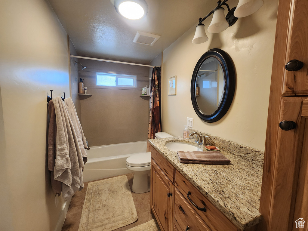 Full bathroom featuring shower / tub combo with curtain, vanity with extensive cabinet space, toilet, and tile flooring