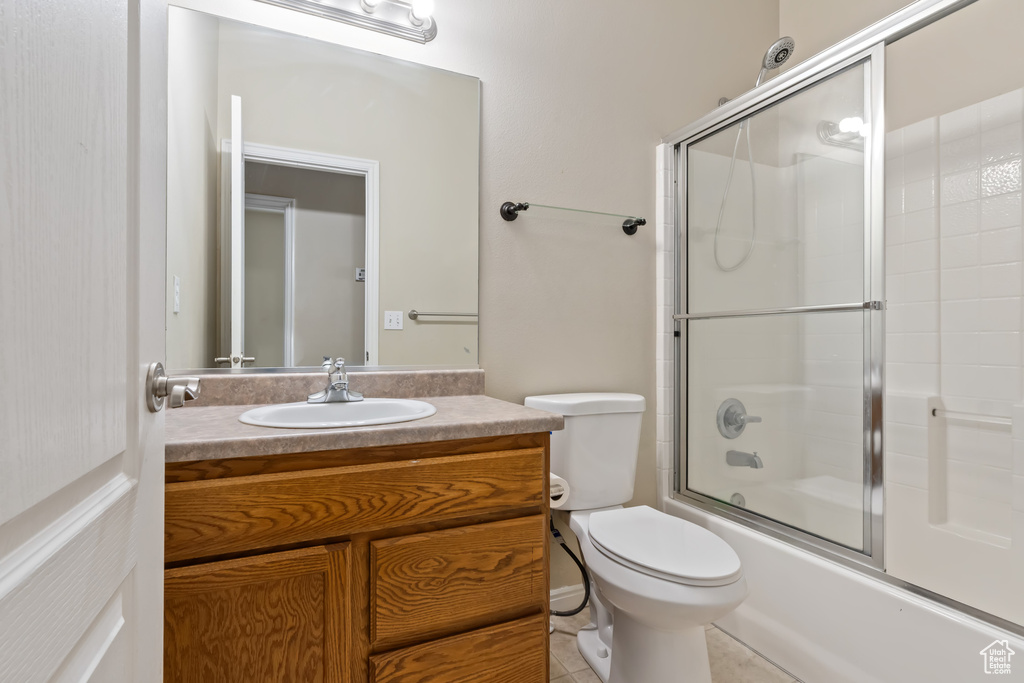Full bathroom featuring vanity, tile flooring, shower / bath combination with glass door, and toilet
