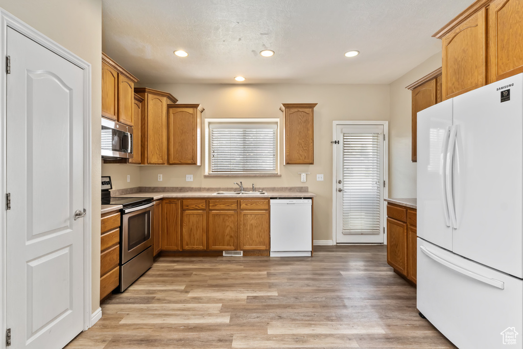 Kitchen featuring appliances with stainless steel finishes, light hardwood / wood-style floors, and sink