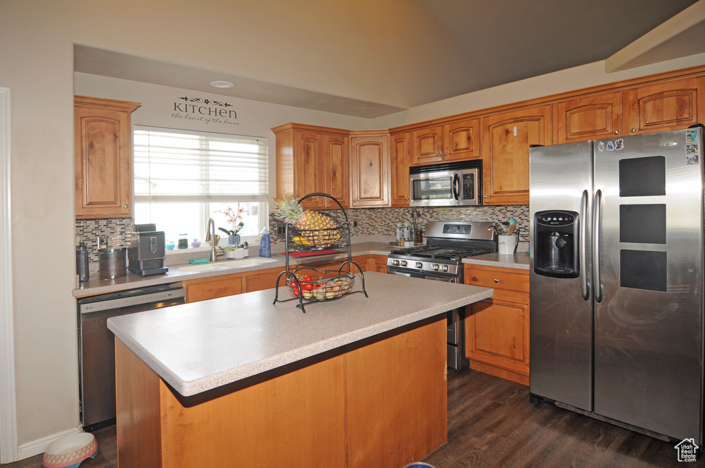 Kitchen featuring a kitchen island, tasteful backsplash, dark hardwood / wood-style floors, and stainless steel appliances