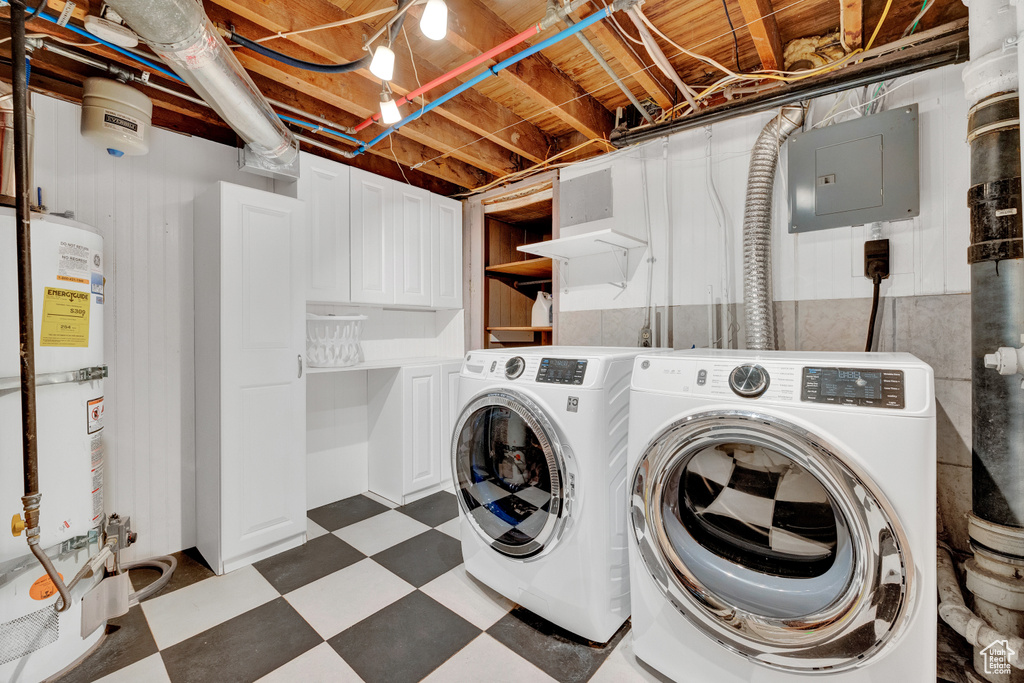 Laundry room featuring cabinets, dark tile floors, hookup for an electric dryer, gas water heater, and washer and dryer