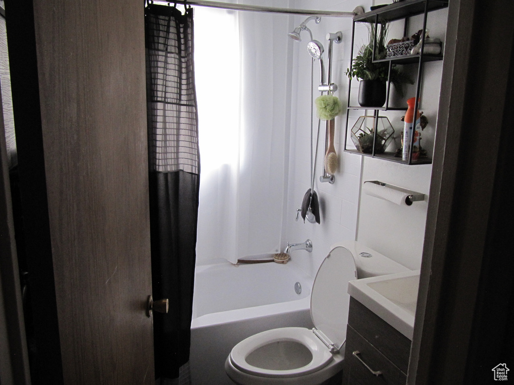 Full bathroom featuring vanity, a healthy amount of sunlight, toilet, and shower / bathtub combination with curtain