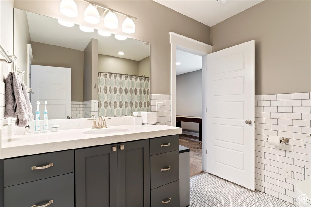 Bathroom featuring tile walls, tile floors, and vanity with extensive cabinet space