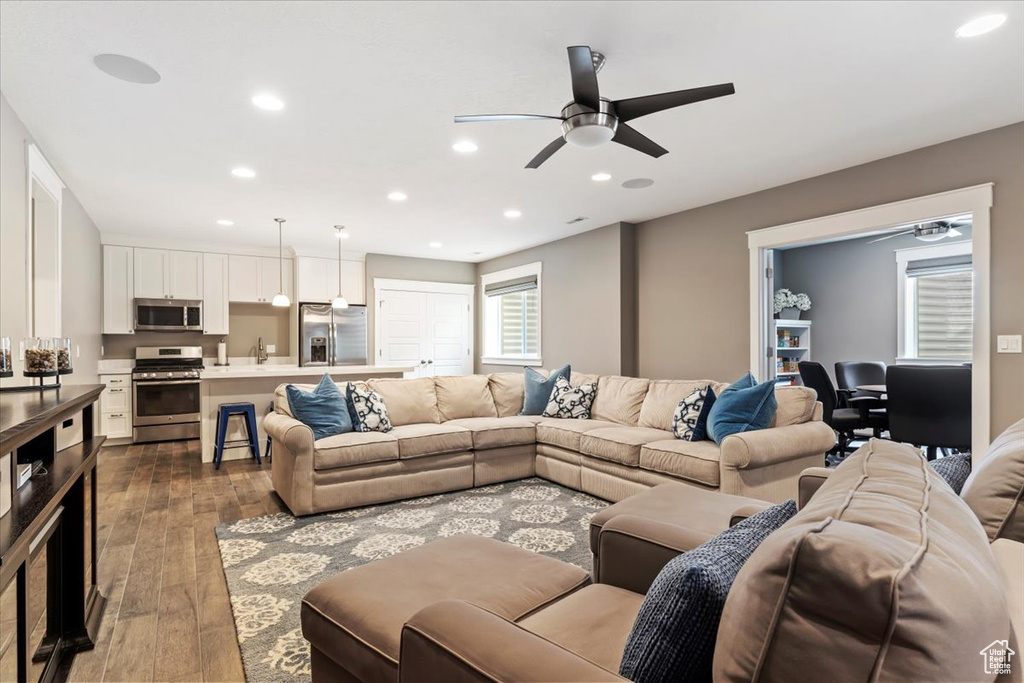 Living room with light hardwood / wood-style floors, ceiling fan, and sink