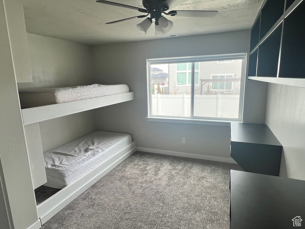 Unfurnished bedroom with ceiling fan and light colored carpet