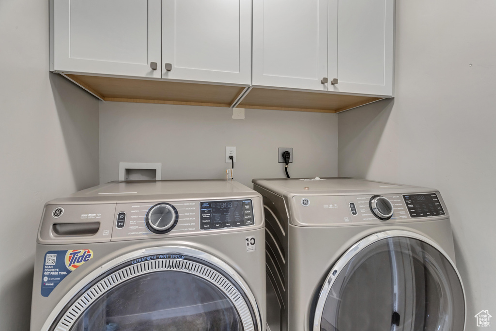 Laundry area featuring cabinets, washer and clothes dryer, washer hookup, and hookup for an electric dryer