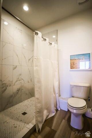 Bathroom with toilet and a shower with shower curtain