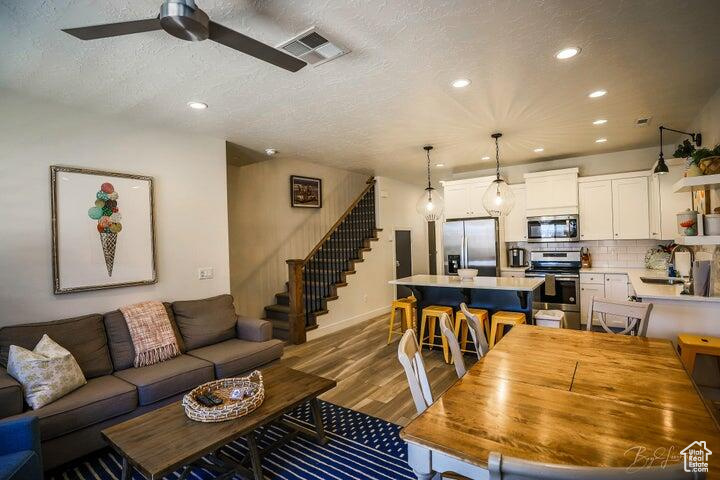 Living room featuring hardwood / wood-style floors, a textured ceiling, and ceiling fan
