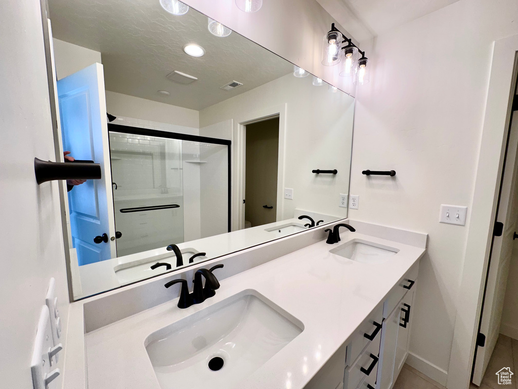 Bathroom featuring dual sinks and vanity with extensive cabinet space