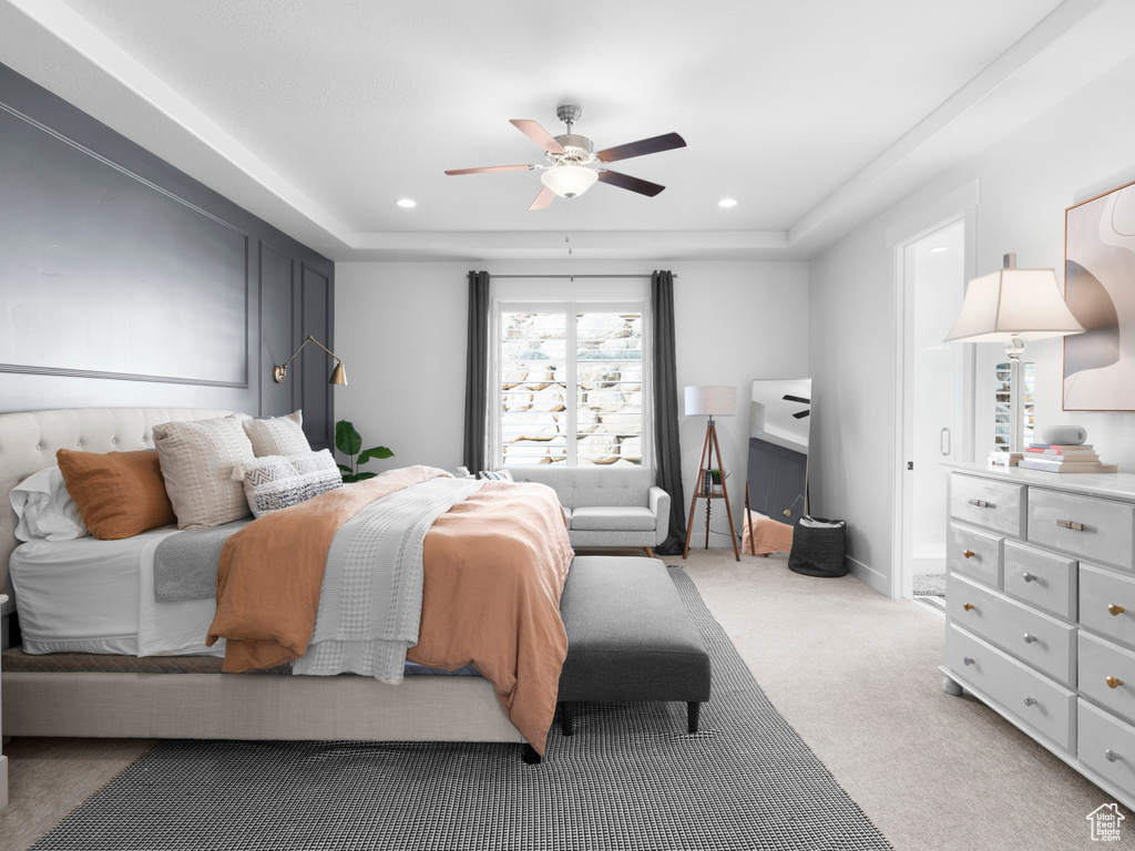 Bedroom featuring a tray ceiling, carpet, and ceiling fan