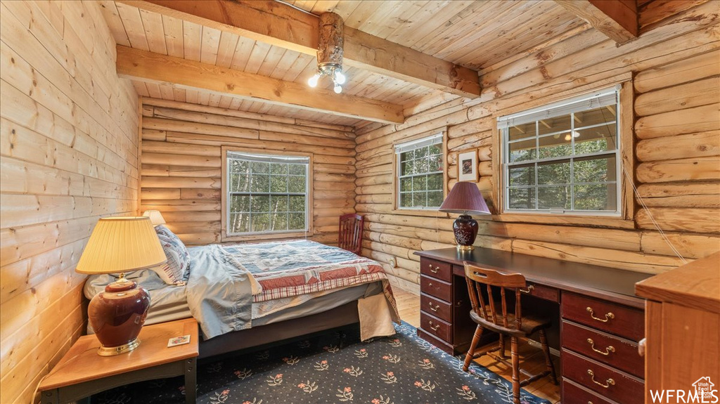 Bedroom with dark wood-type flooring, log walls, wooden ceiling, and beamed ceiling