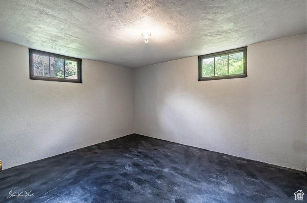 Basement with a textured ceiling and dark carpet